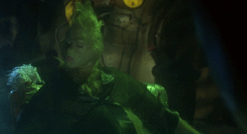 On the couch, drinking soda.