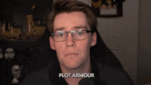 a man with glasses and the word plot armour on the bottom right